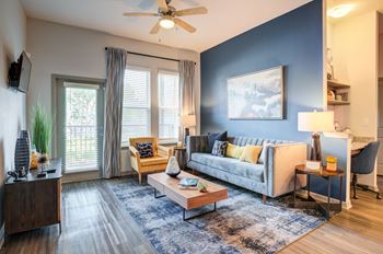 An open living room with blue walls and a ceiling fan